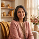 A smiling South Asian parent in a warm, modern home setting, representing a satisfied customer.